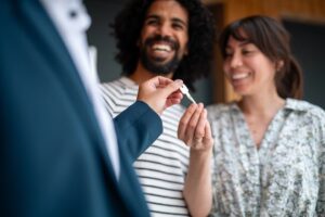 Real estate agent handing keys to couple