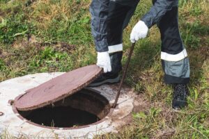 Worker opening septic tank lid