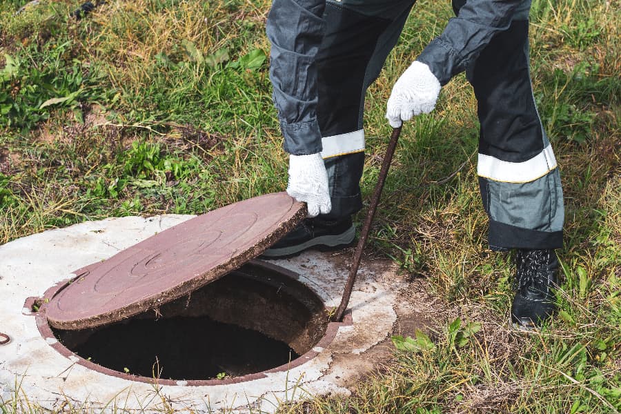 Worker opening septic tank lid